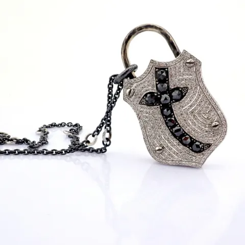 An exquisite, convertible clasp cross necklace embellished with gold and diamonds on silver