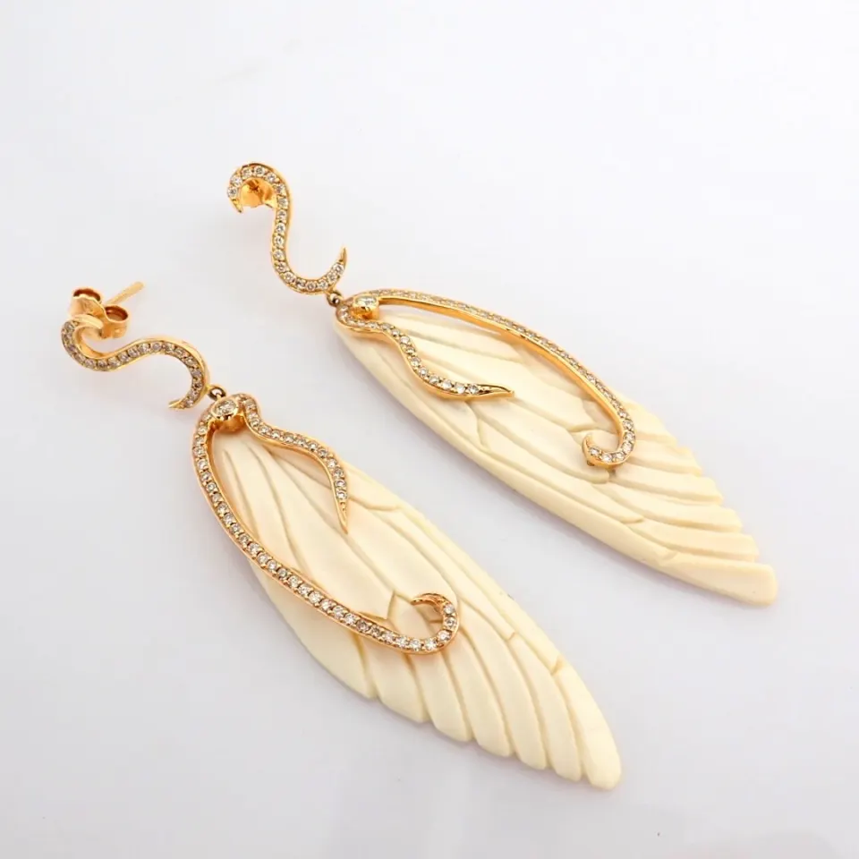 An exquisite bone-carved wing earrings  detailed with brilliant diamonds and gold