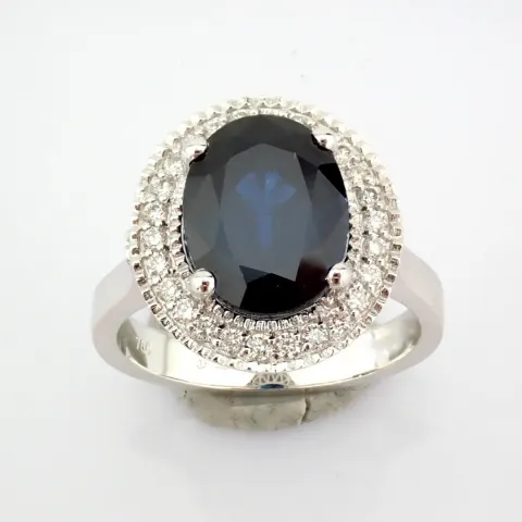 An exquisite 18k white gold cluster ring detailed with sapphire and brilliant diamonds