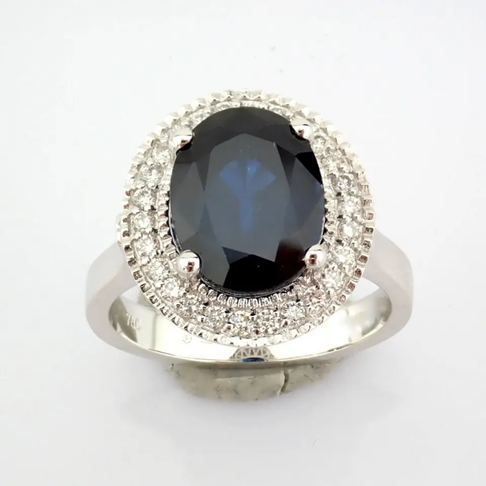 An exquisite 18k white gold cluster ring detailed with sapphire and brilliant diamonds
