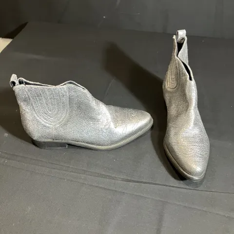 Hush silver boots worn by a body double