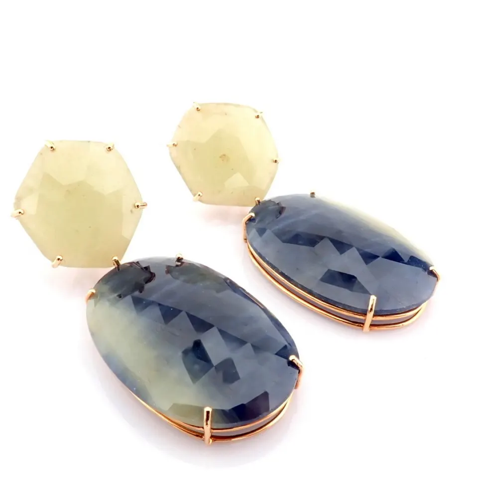An exquisite gold earrings detailed with slice cut rough sapphire in the center