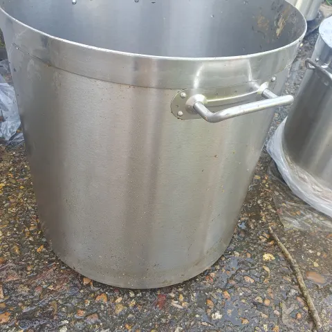 A set of 5 large stainless steel pots with lids.