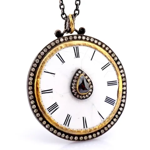 An exquisite necklace made of gold and silver, featuring an antique watch dial adorned with diamonds