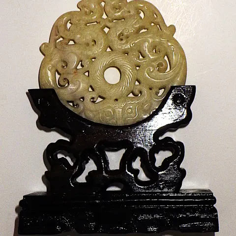A White Jade Intricately Carved Chinese Amulet On A Custom Wooden Base