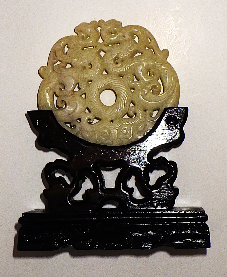 A White Jade Intricately Carved Chinese Amulet On A Custom Wooden Base