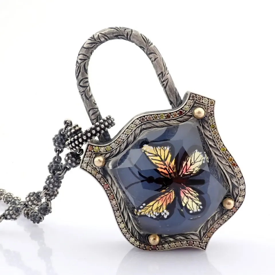 Clasp necklace with gold, topaz, reversaly engraved intaglio butterfly, and diamonds on silver