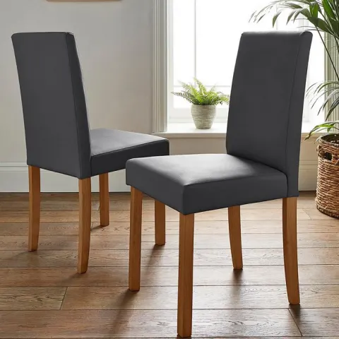 (35) RRP £179. Pair Of Ava Faux Leather Dining Chairs Grey/Oak. Dimensions: (H90 x W43 x D50cm).