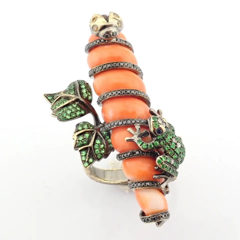 An exquisite ring detailed with coral, green garnet and brilliant diamonds