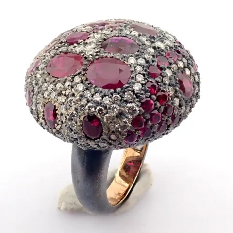 An Exquisite Ring Detailed With Vibrant Rubies, Brilliant Diamonds and Gold On Silver