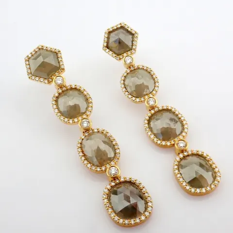 Gold earrings detailed with slice cut rough diamonds in the center and brilliant diamonds on frame