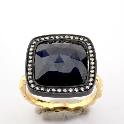 Gold ring detailed with slice cut rough sapphire in the center, brilliant diamonds on silver frame