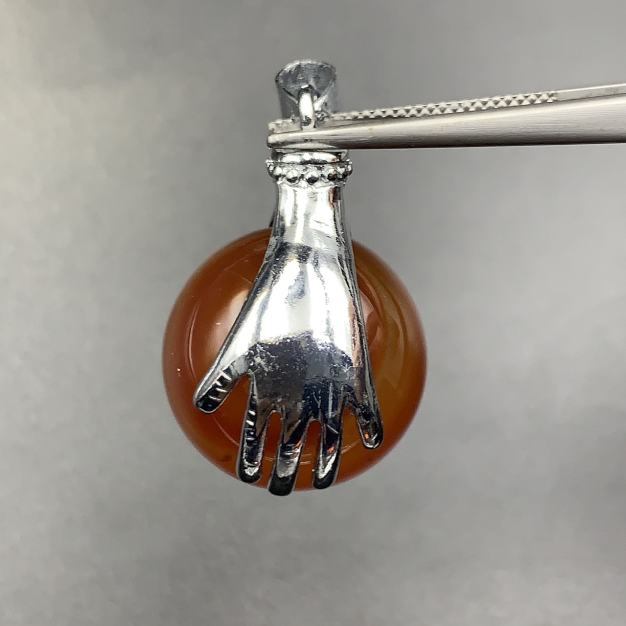 74.45Cts Awesome Natural Carnelian Sphere Agate With Holding Hands Stainless Steel Pendant. BCM-5
